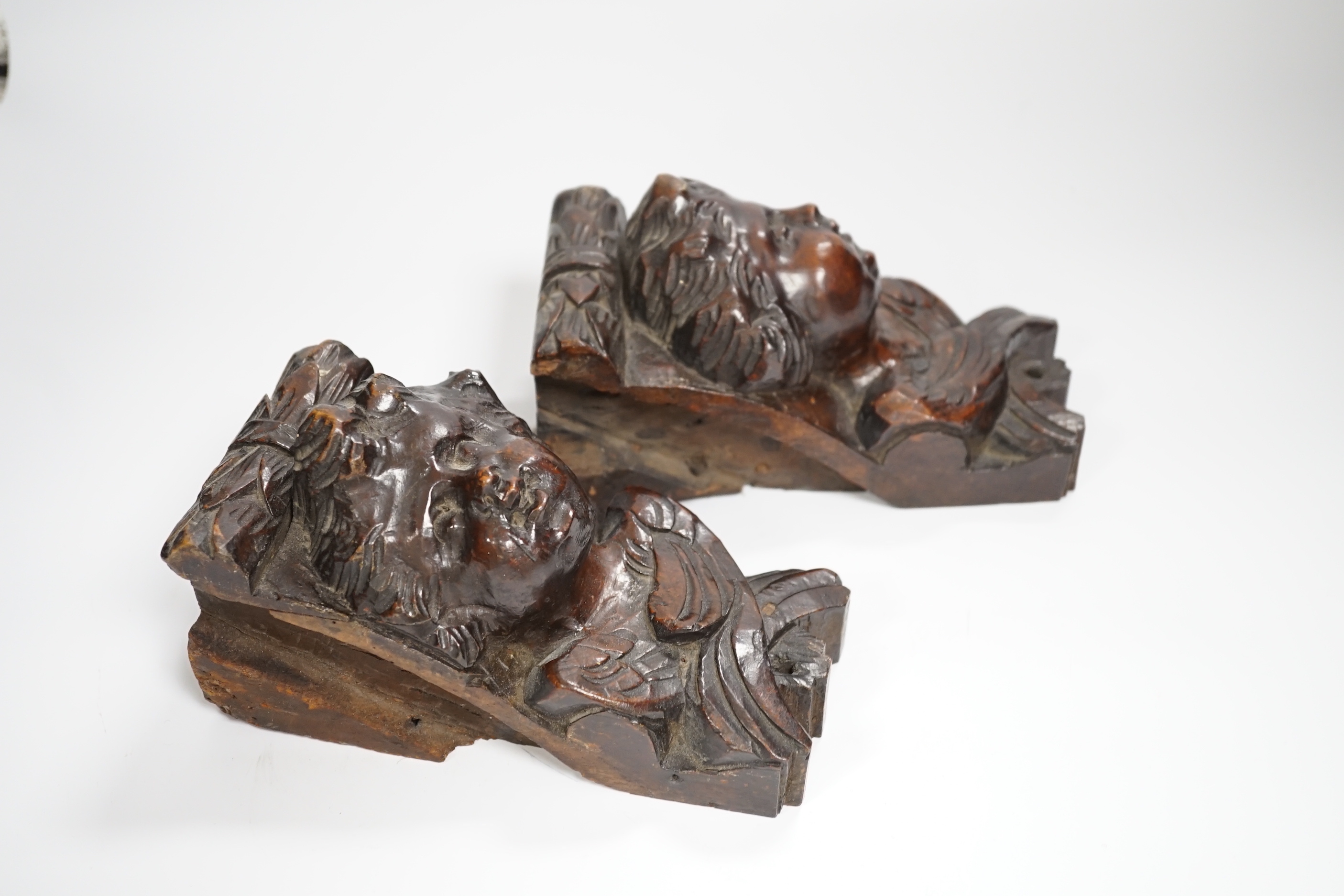A pair of Italian carved walnut putti corbels, 18cm high
